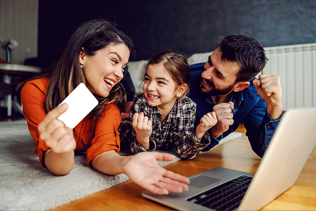 A family with a laptop and credit card.